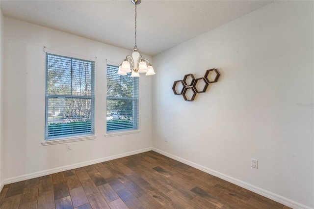 unfurnished room featuring a notable chandelier and wood-type flooring