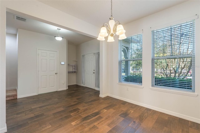 unfurnished dining area featuring dark hardwood / wood-style floors and a notable chandelier