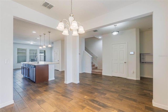 kitchen with sink, stainless steel dishwasher, dark hardwood / wood-style flooring, an island with sink, and pendant lighting