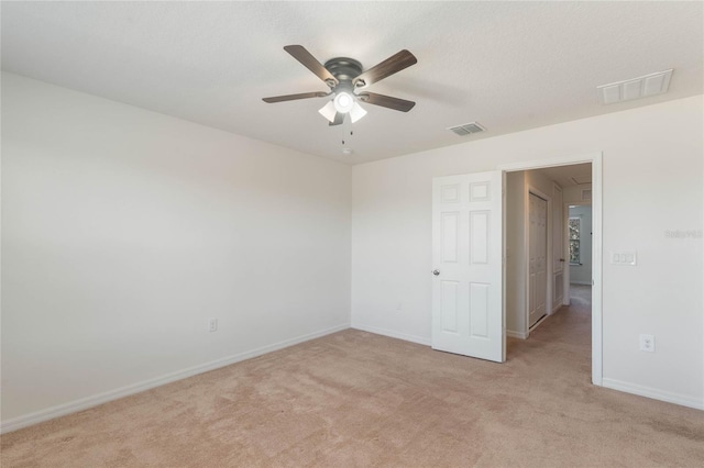 carpeted spare room featuring a textured ceiling and ceiling fan