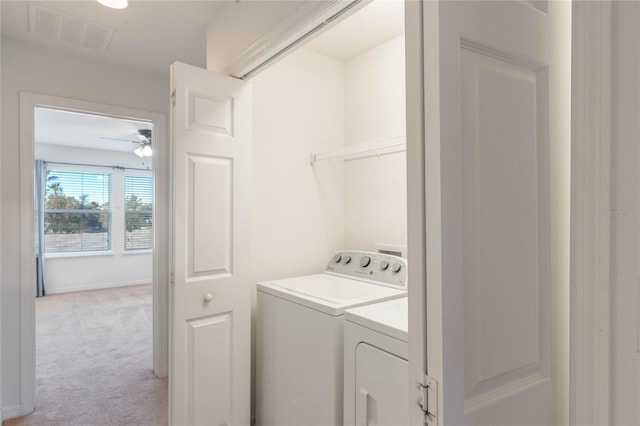 laundry room with washer and dryer, light colored carpet, and ceiling fan