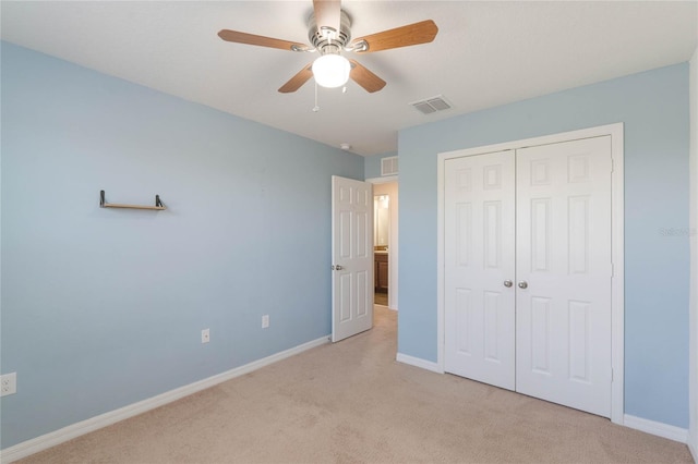 unfurnished bedroom featuring light colored carpet, a closet, and ceiling fan