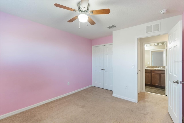 unfurnished bedroom with ceiling fan, light colored carpet, and a closet