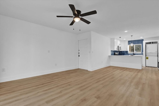 unfurnished living room featuring ceiling fan and light wood-type flooring