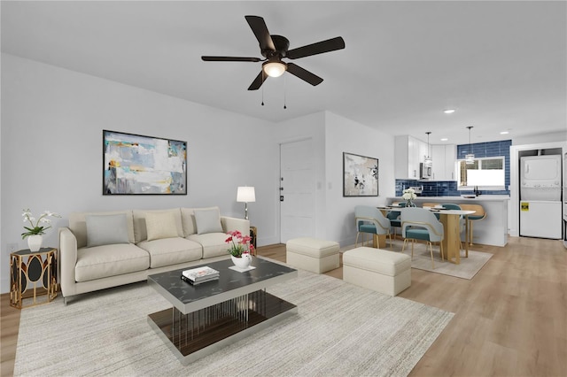 living room featuring sink, light hardwood / wood-style floors, and ceiling fan