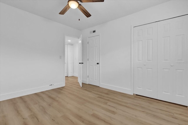 unfurnished bedroom featuring two closets, ceiling fan, and light wood-type flooring