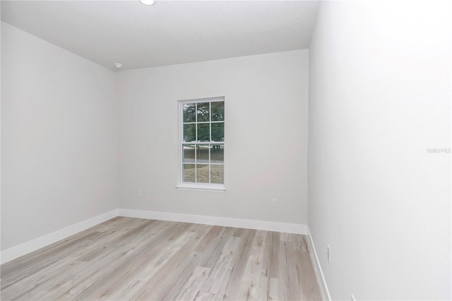 spare room with light wood-style floors and baseboards