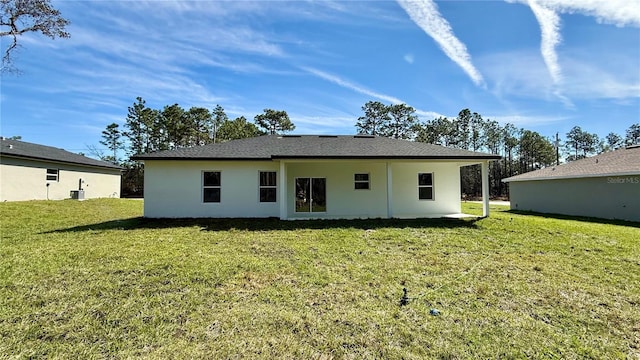 rear view of property with central AC unit, a lawn, and stucco siding