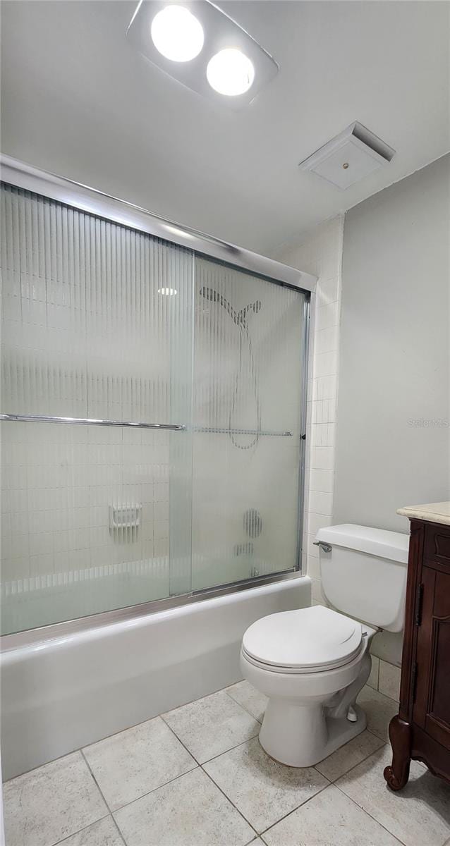 full bathroom with tile patterned floors, vanity, toilet, and combined bath / shower with glass door