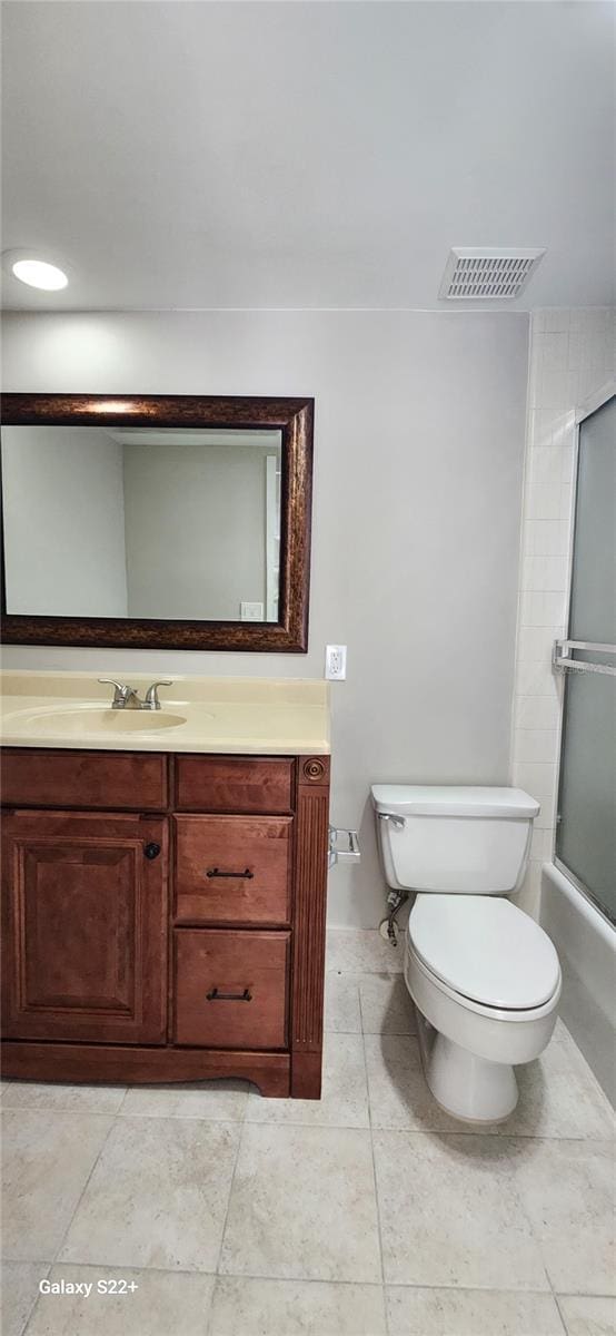 full bathroom with enclosed tub / shower combo, vanity, and toilet