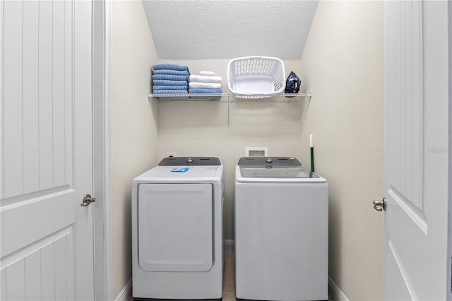 laundry room with a textured ceiling and independent washer and dryer