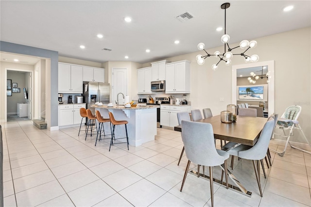 tiled dining room featuring sink and a chandelier