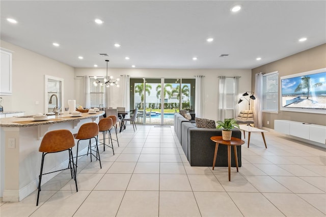 tiled living room with a notable chandelier