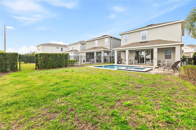 back of property with a fenced in pool, a patio, and a yard