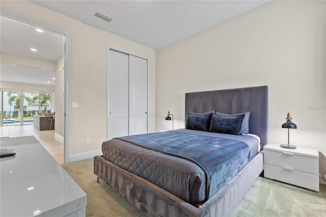 bedroom featuring light carpet and a closet