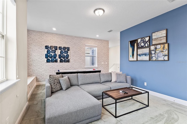 living room featuring brick wall and light colored carpet