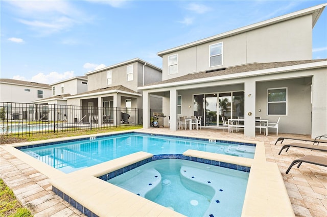 view of swimming pool featuring an in ground hot tub and a patio area