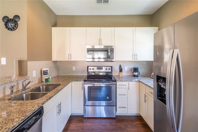 kitchen featuring white cabinetry, sink, light stone counters, and appliances with stainless steel finishes