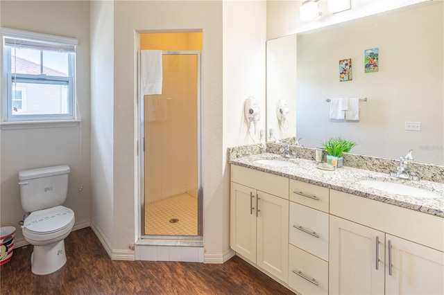 bathroom featuring vanity, toilet, hardwood / wood-style floors, and a shower with shower door