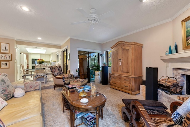 living room featuring a fireplace, ceiling fan, crown molding, light carpet, and a textured ceiling