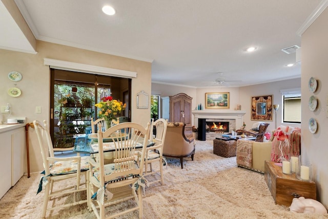 dining area featuring ornamental molding, light colored carpet, and ceiling fan