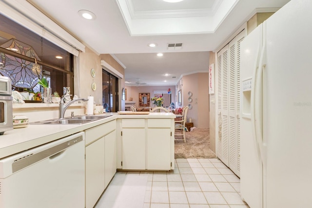 kitchen with sink, ornamental molding, a tray ceiling, kitchen peninsula, and white appliances