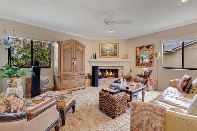 carpeted living room with ceiling fan, ornamental molding, and a fireplace