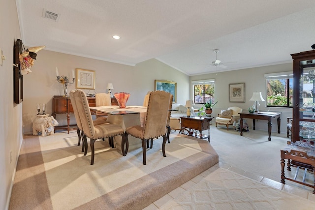 carpeted dining space with lofted ceiling, a wealth of natural light, ornamental molding, and ceiling fan