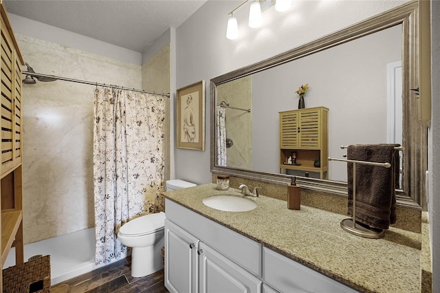 bathroom with toilet, a shower with curtain, wood-type flooring, a textured ceiling, and vanity