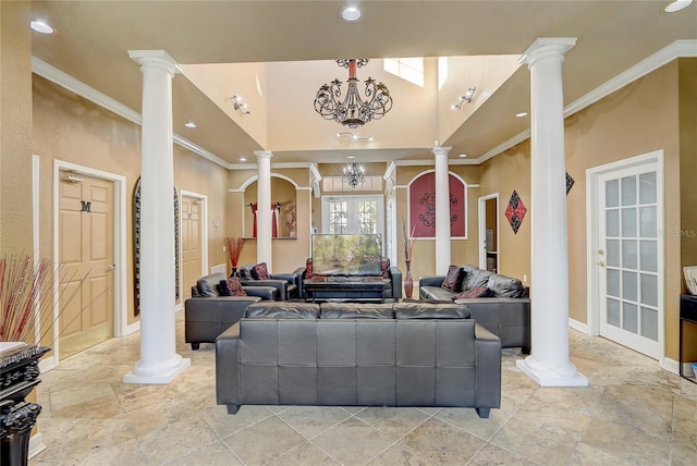 living room with crown molding, a chandelier, and ornate columns