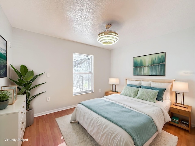 bedroom featuring a textured ceiling and light wood-type flooring