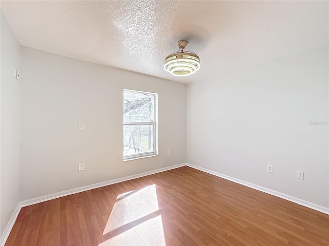 spare room featuring hardwood / wood-style flooring and a textured ceiling