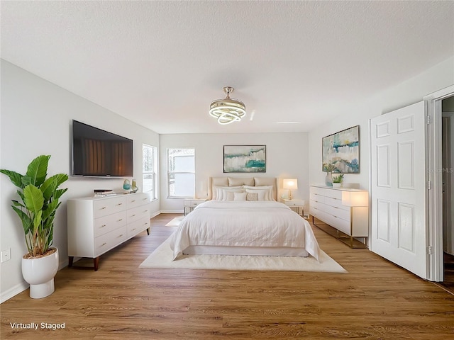 bedroom featuring hardwood / wood-style floors and a textured ceiling