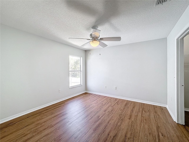 empty room featuring hardwood / wood-style flooring, ceiling fan, and a textured ceiling