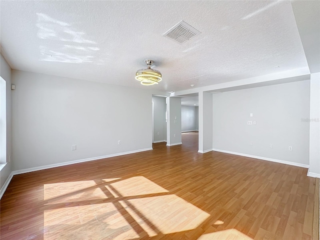 spare room featuring wood-type flooring and a textured ceiling