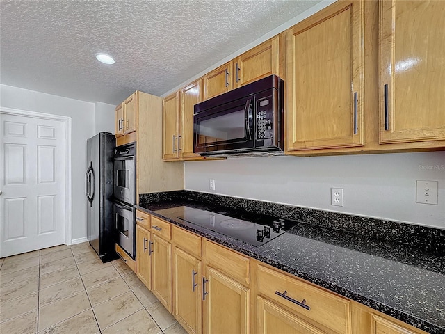 kitchen featuring light tile patterned flooring, dark stone countertops, a textured ceiling, and black appliances