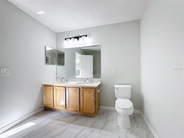 bathroom featuring vanity, a textured ceiling, and toilet