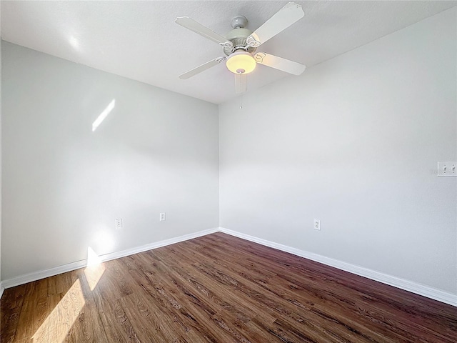 spare room with dark hardwood / wood-style flooring and ceiling fan