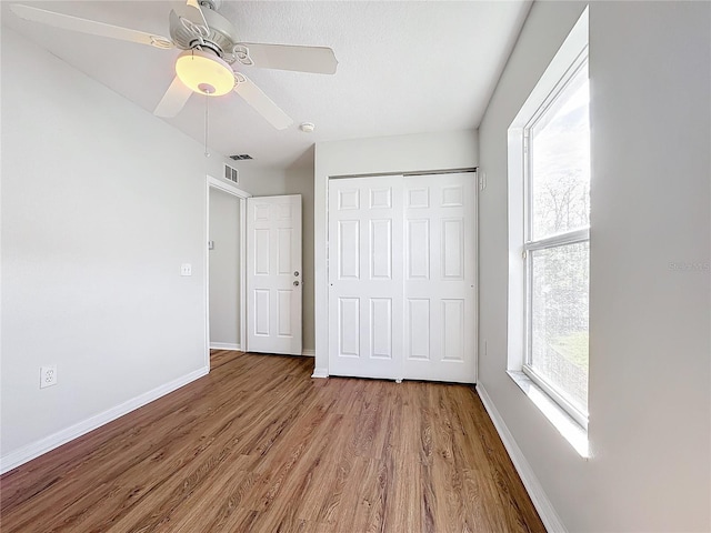 unfurnished bedroom with ceiling fan, hardwood / wood-style floors, and a closet