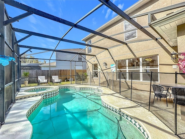 view of pool featuring an in ground hot tub, a patio area, and glass enclosure