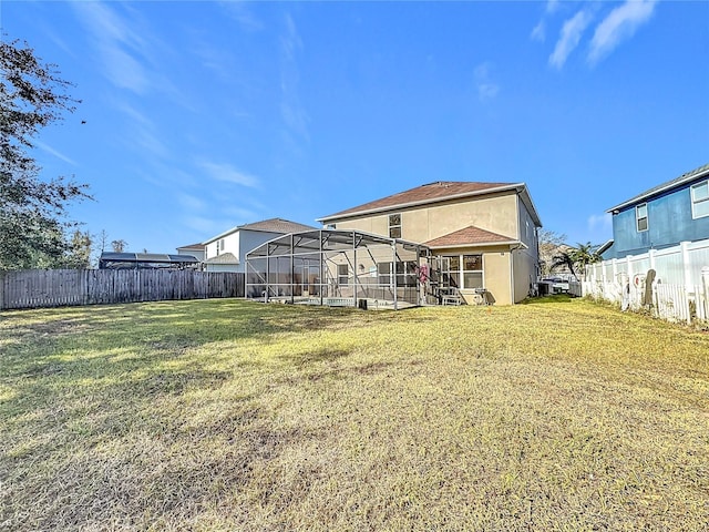 back of property featuring a lanai and a yard