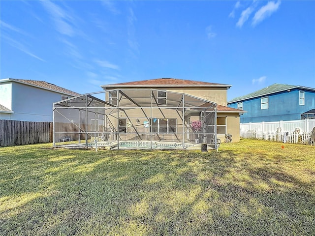 back of house with a pool, a yard, and glass enclosure