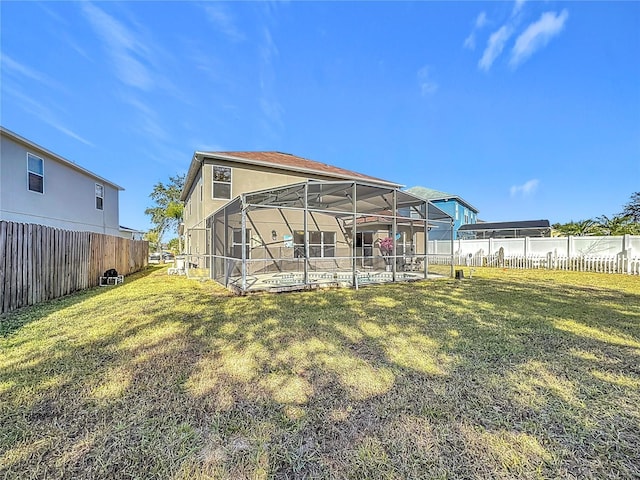 rear view of property featuring a pool, a yard, and glass enclosure