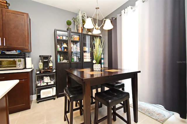 tiled dining room with a chandelier