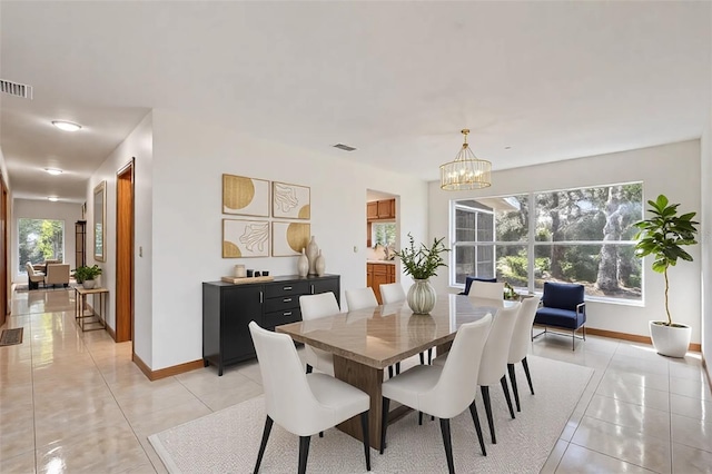 tiled dining room featuring a chandelier