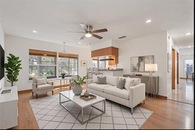 living room with ceiling fan and light wood-type flooring