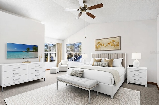 bedroom with ceiling fan, lofted ceiling, carpet floors, and a textured ceiling