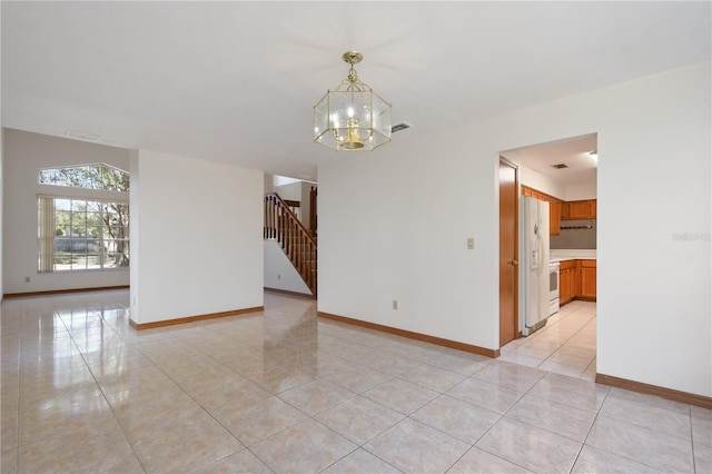 tiled empty room featuring a chandelier