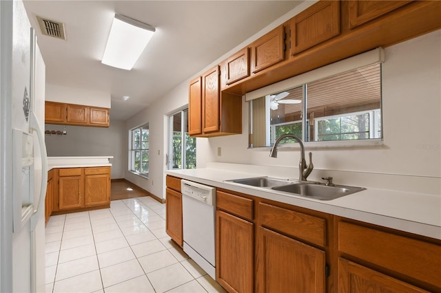 kitchen with sink, light tile patterned floors, and white appliances