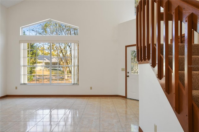 tiled foyer entrance with high vaulted ceiling